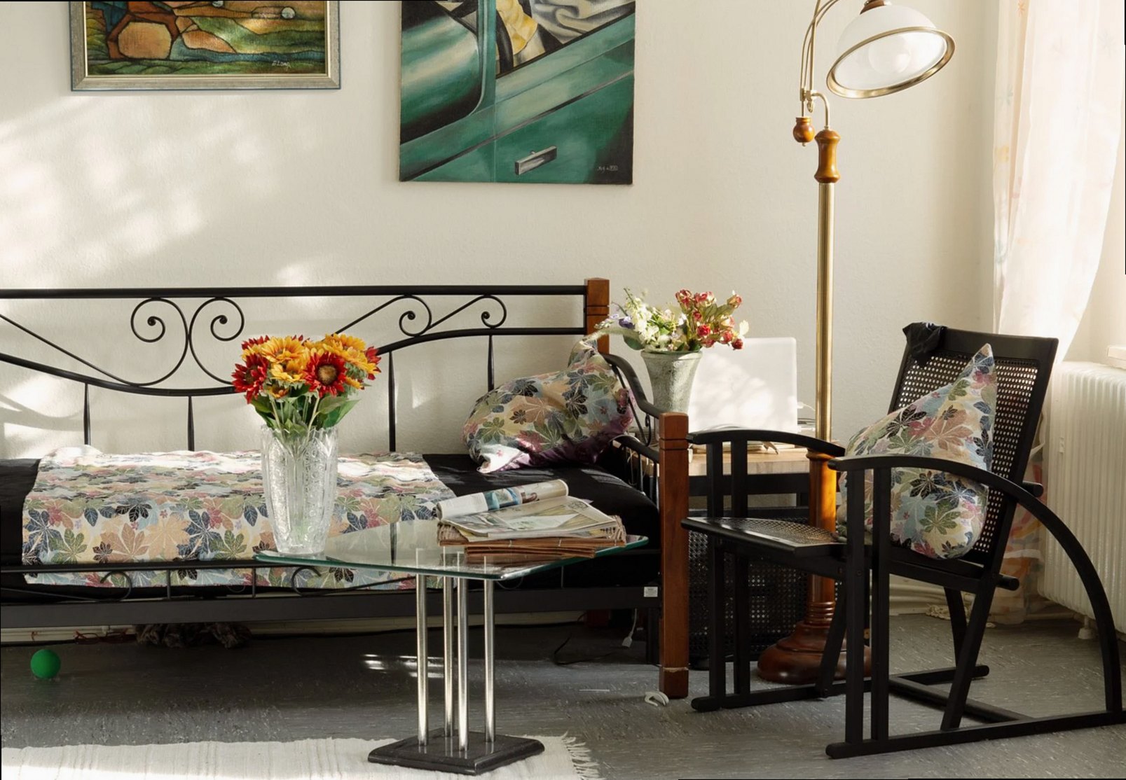 Charming living room featuring artistic decor, floral pillows, and cozy seating in natural light.